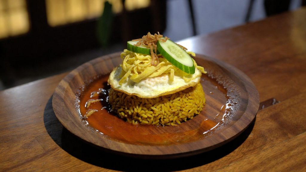 Piring berisi nasi goreng Jawa dengan telur ceplok dan kerupuk udang