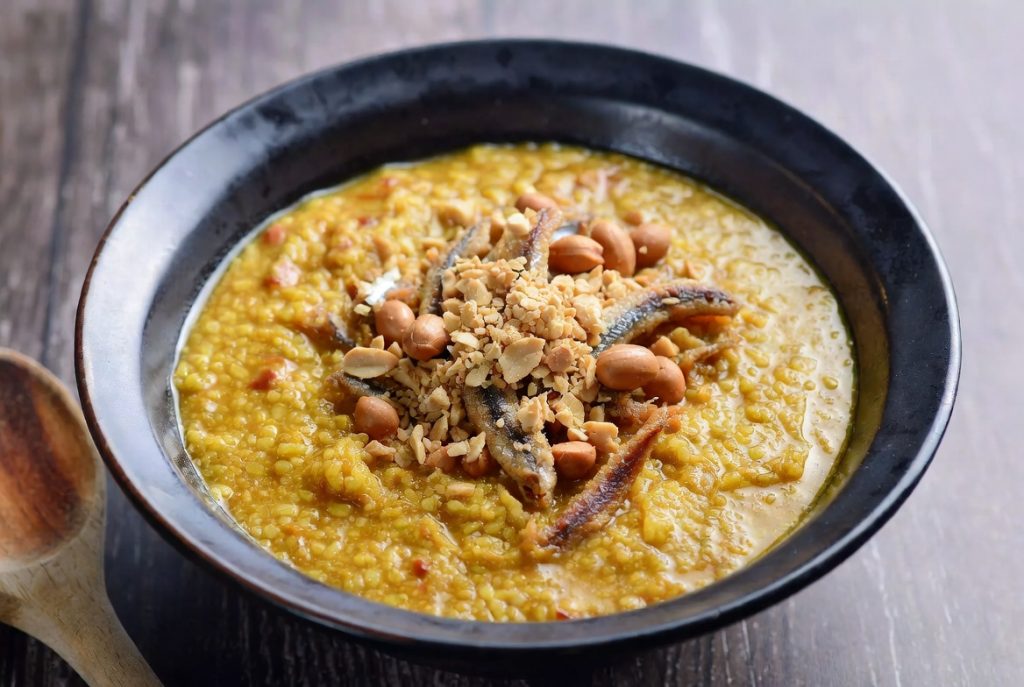 Sajian mangkuk Bubur Pedas khas Sambas dengan taburan kacang dan teri